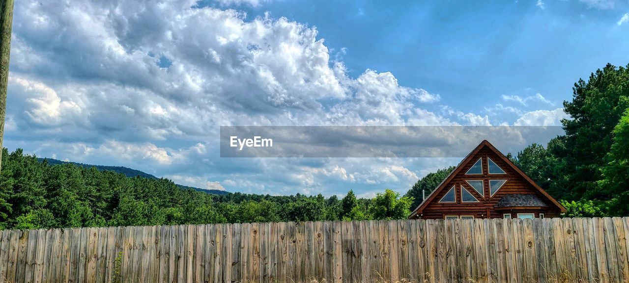 PANORAMIC VIEW OF COTTAGE AMIDST TREES AND BUILDING