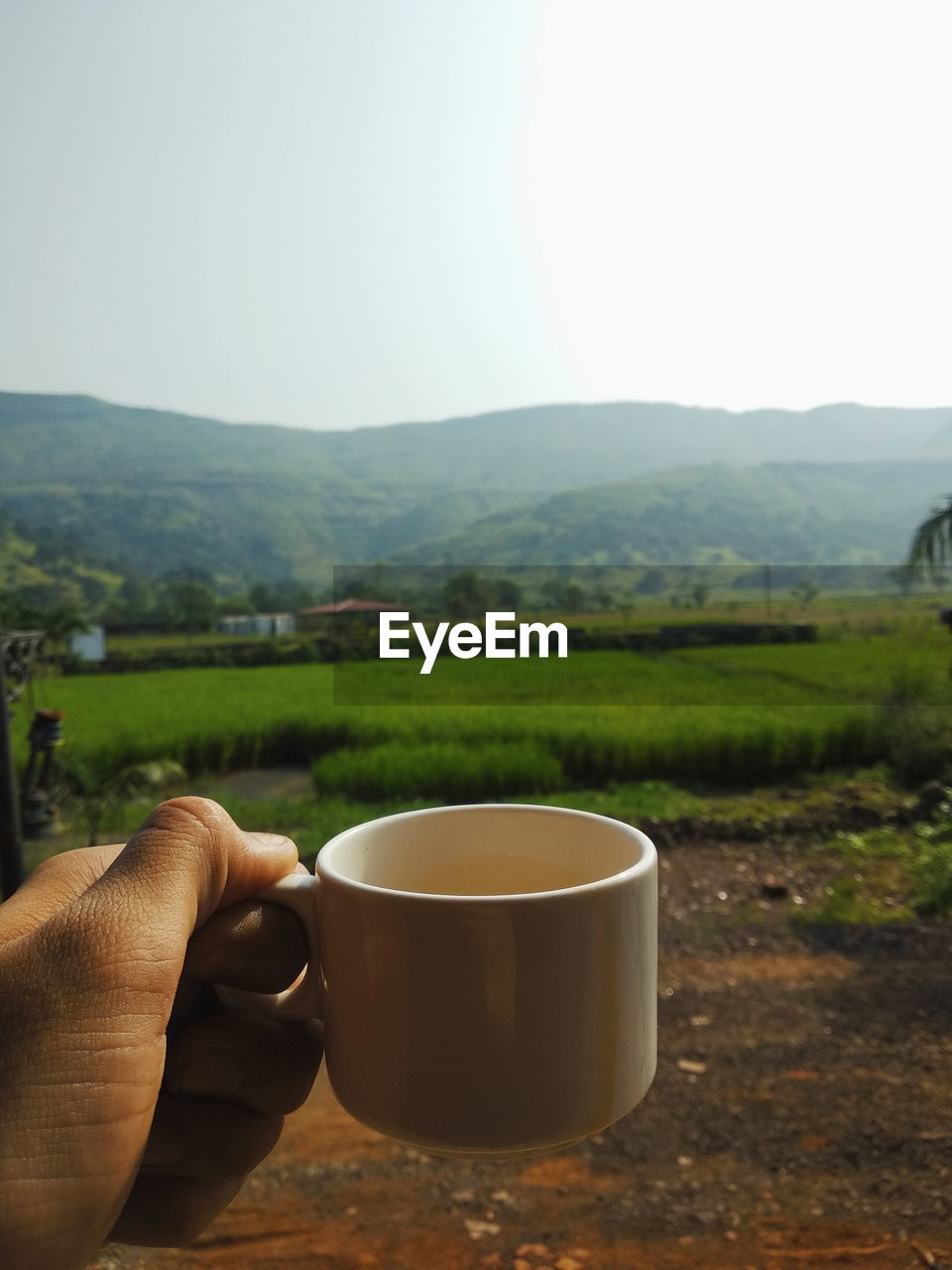 Coffee cup on table by mountains against sky