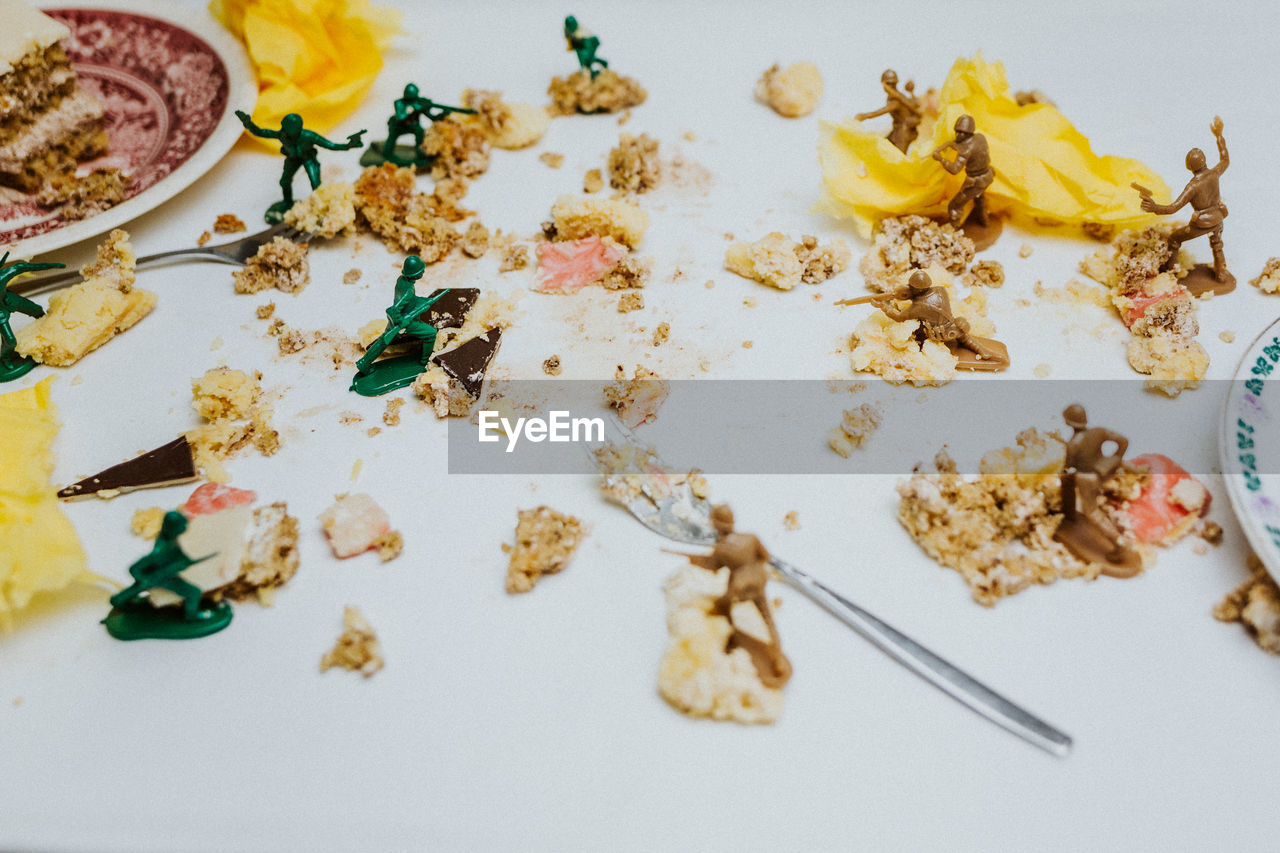 Toy soldiers fight in between pieces of cakes about having a dessert or not - close up food on table