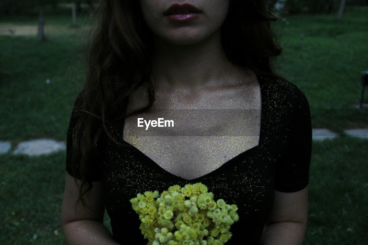 Close-up of woman holding plant with glitter