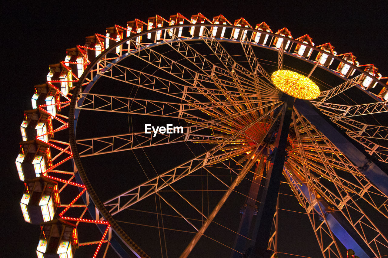 low angle view of illuminated ferris wheel against sky at night