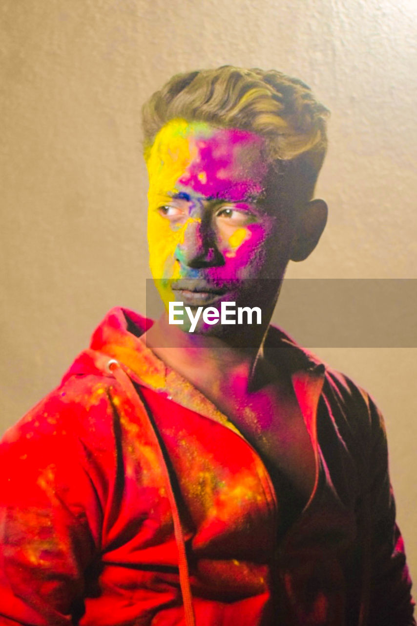 one person, multi colored, portrait, adult, paint, holi, celebration, studio shot, indoors, red, yellow, human face, headshot, waist up, face paint, body paint, tradition, young adult, person, vibrant color, men, painting, front view, art, human head, looking at camera, creativity, clothing