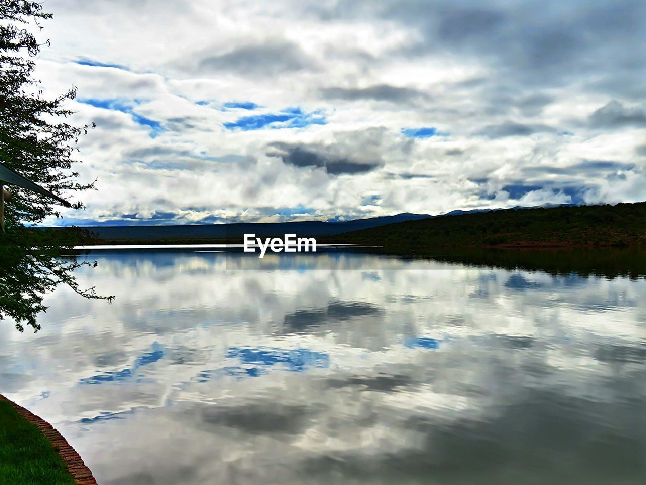 SCENIC VIEW OF LAKE AGAINST CLOUDY SKY