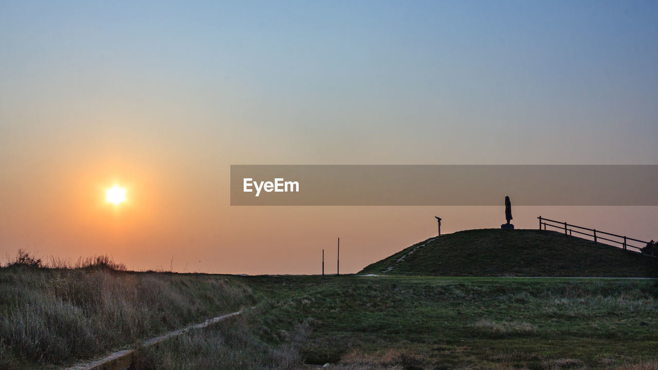 Scenic view of field against sky during sunset