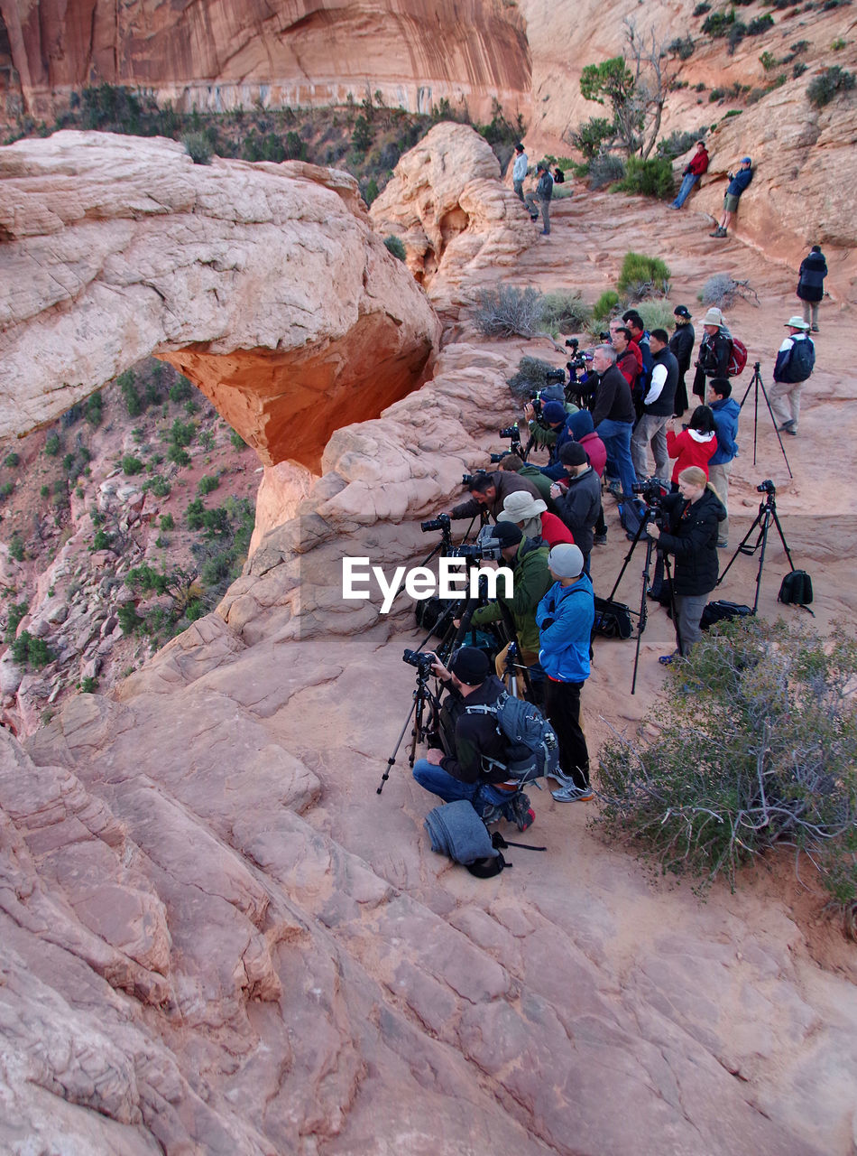 High angle view of people photographing on rock formation