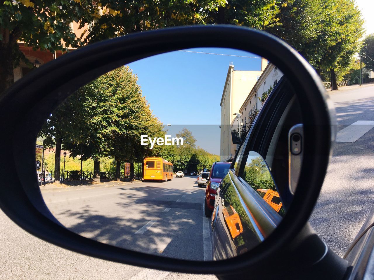 CLOSE-UP OF CAR PARKED ON ROAD AGAINST TREES