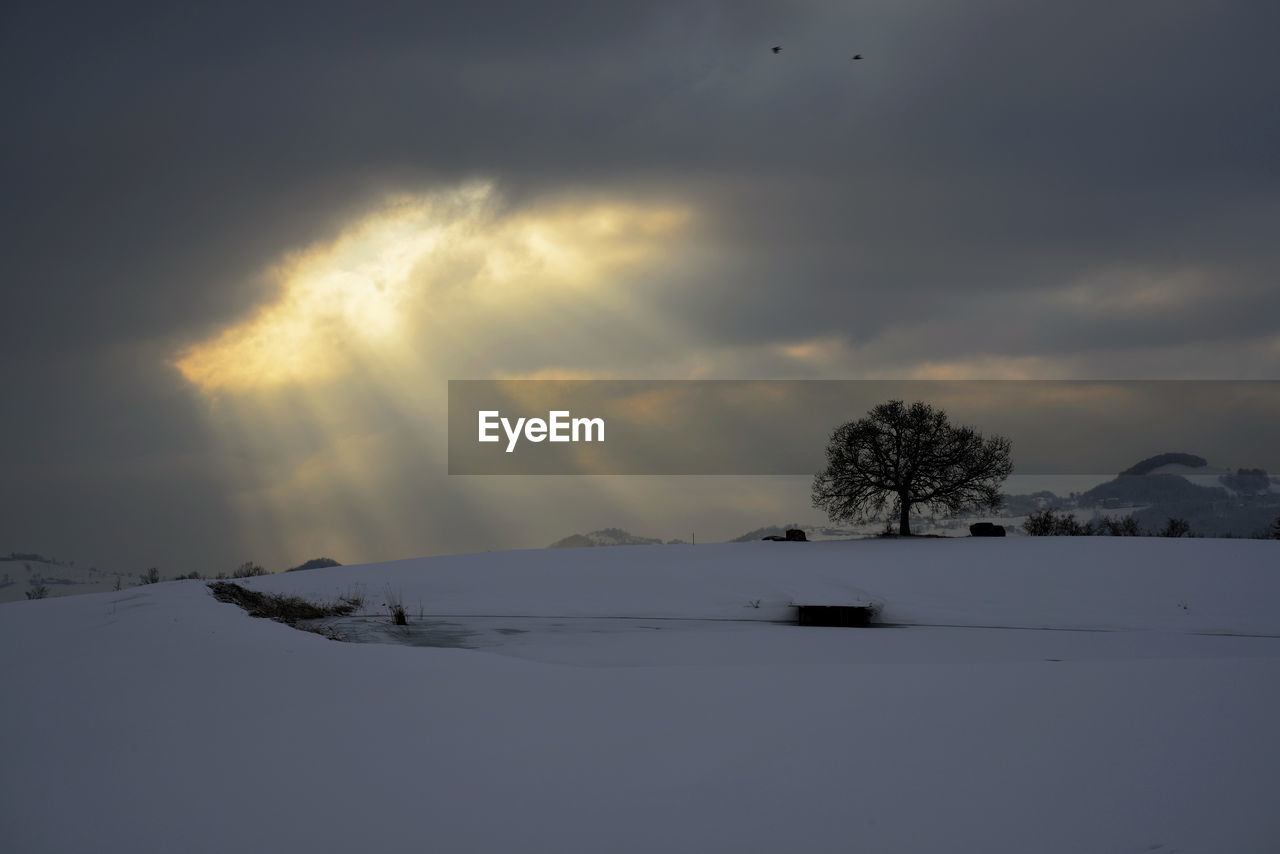 Scenic view of snow field against sky during sunset