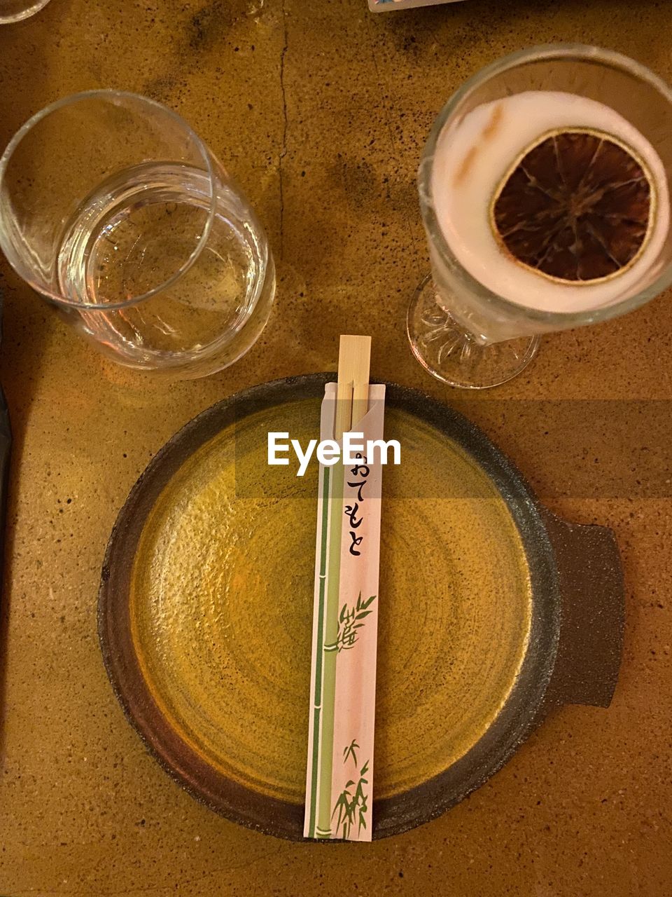 HIGH ANGLE VIEW OF TEA CUP ON GLASS TABLE