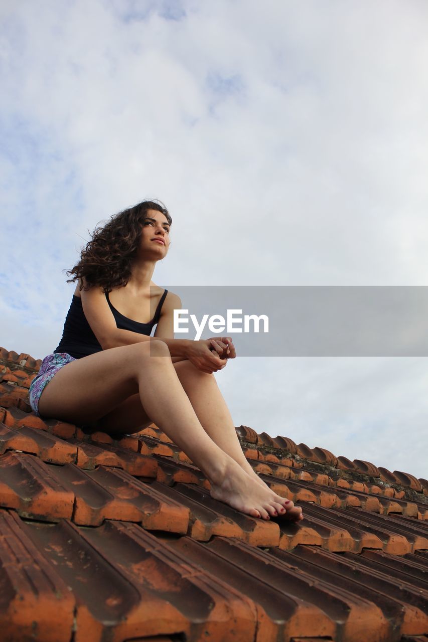 A beautiful woman is sitting on the roof