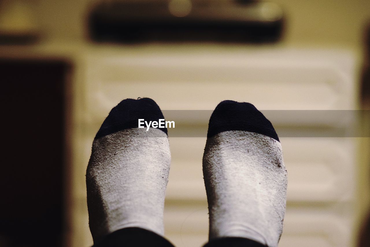 Low section of person wearing socks at home