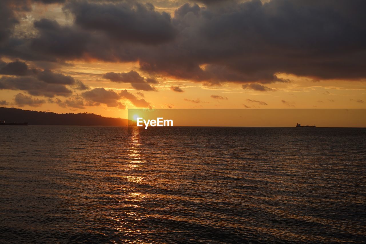 SCENIC VIEW OF SEA AGAINST ORANGE SKY DURING SUNSET