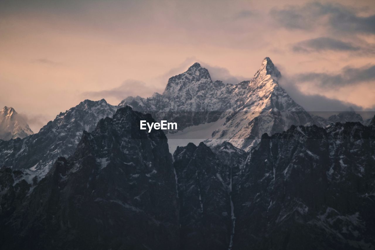 Scenic view of snowcapped mountains against sky during sunset