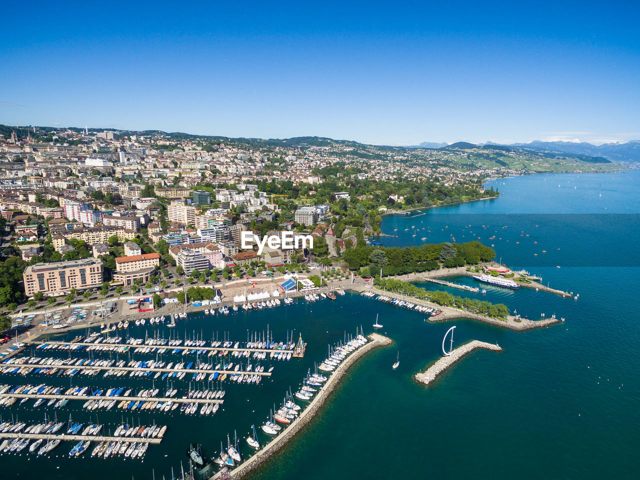 HIGH ANGLE VIEW OF TOWNSCAPE AND SEA AGAINST SKY