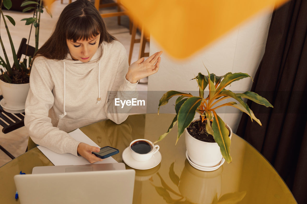 Woman home office and distance remote working. a young female businesswoman sitting at a desk 