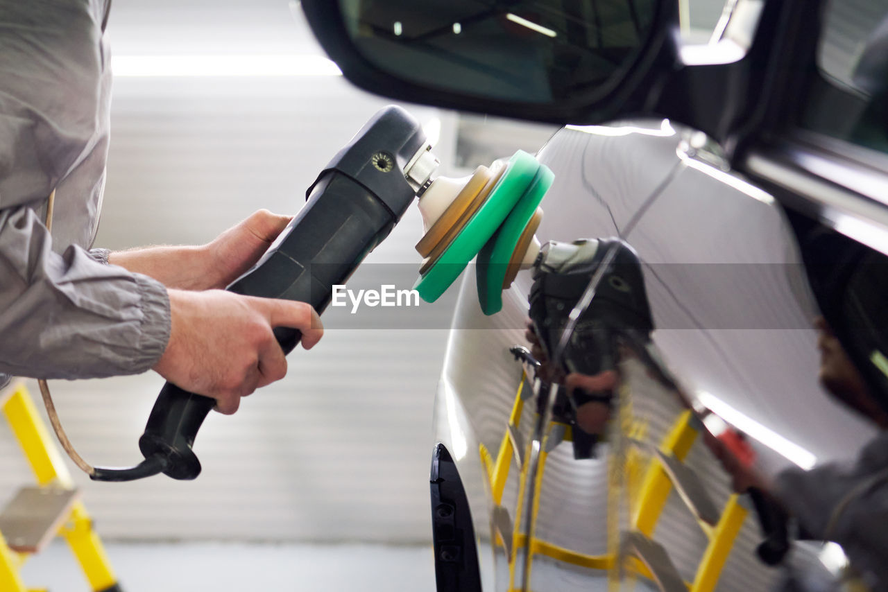 Man holding camera while standing in car