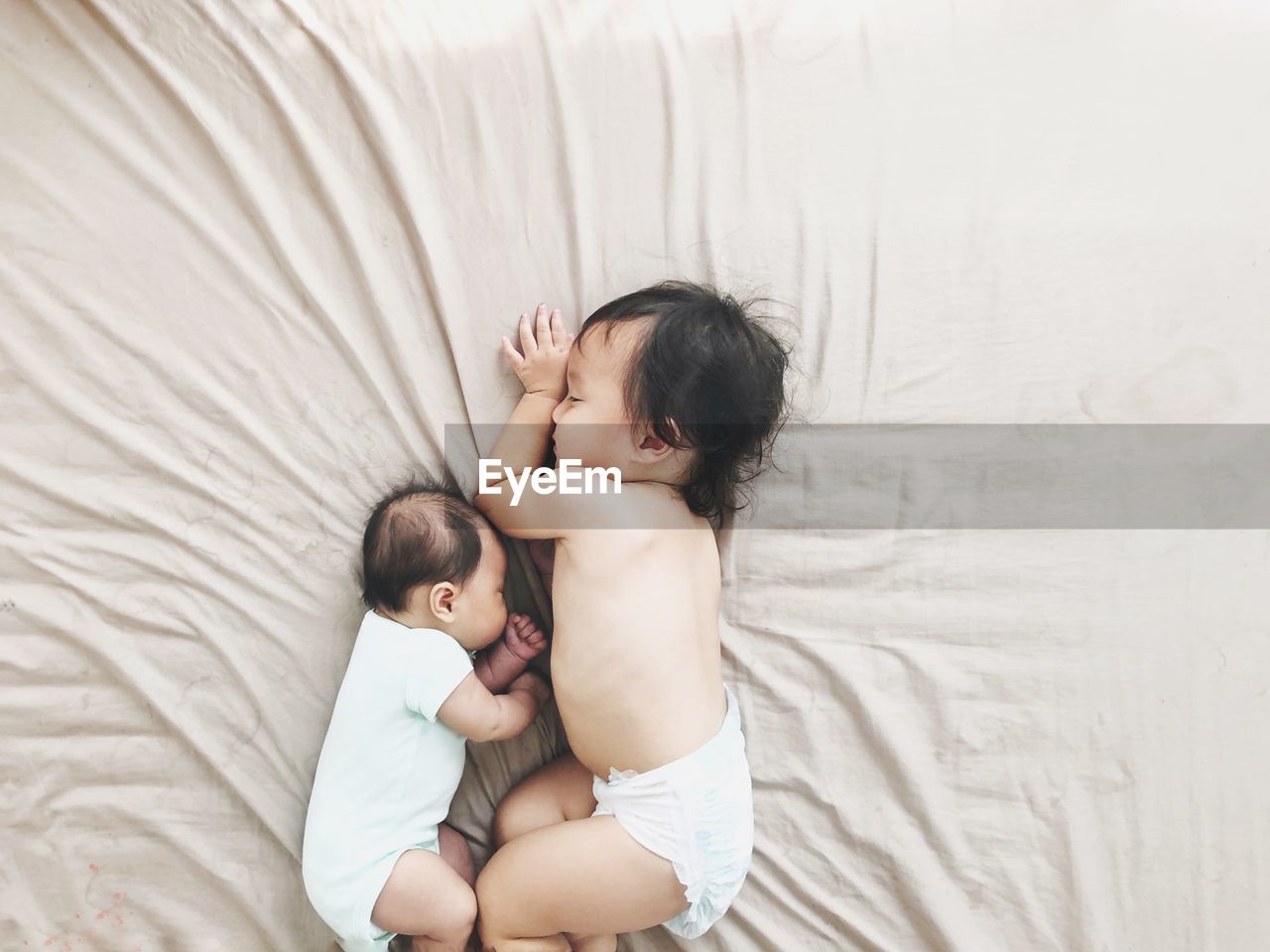 Directly above shot of babies playing on bed