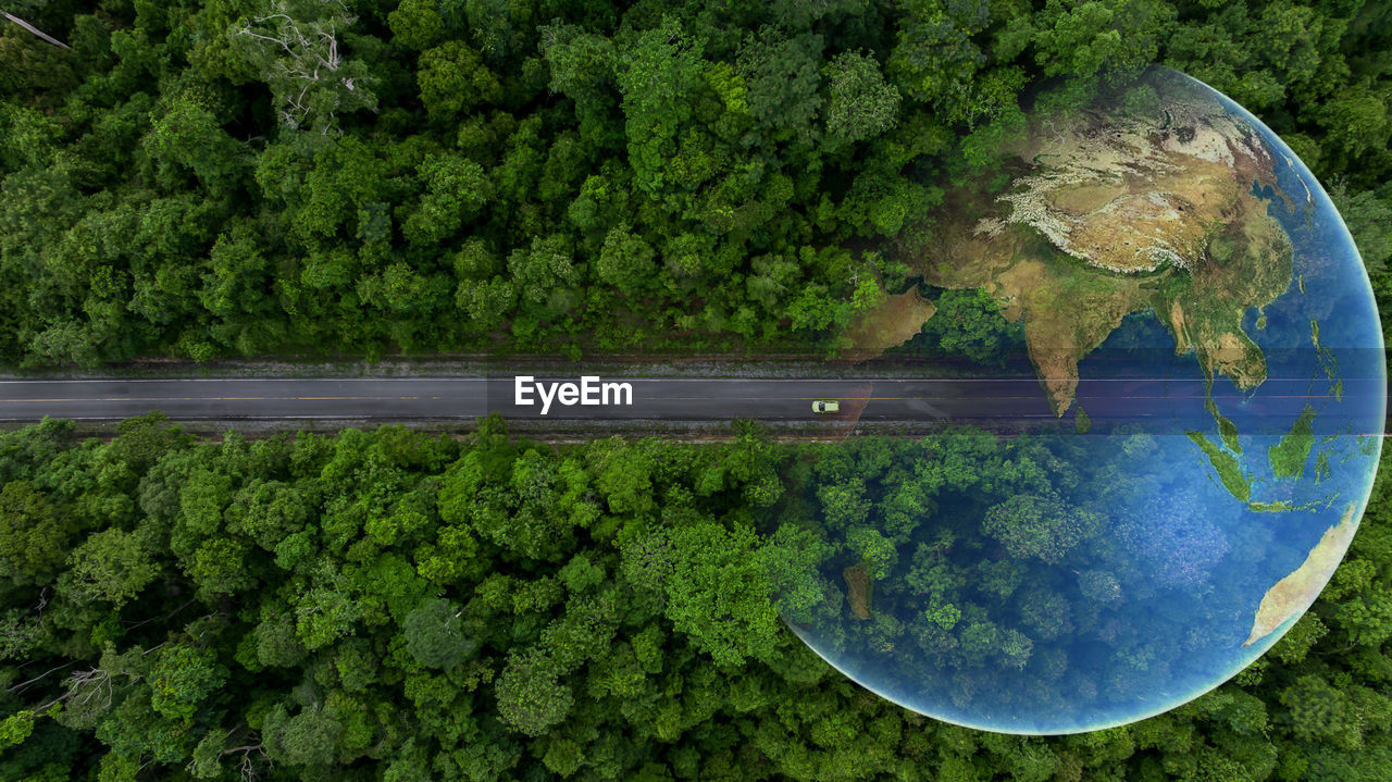 Aerial top view globe planet with electric vehicle car on asphalt road forest in tropical rainforest