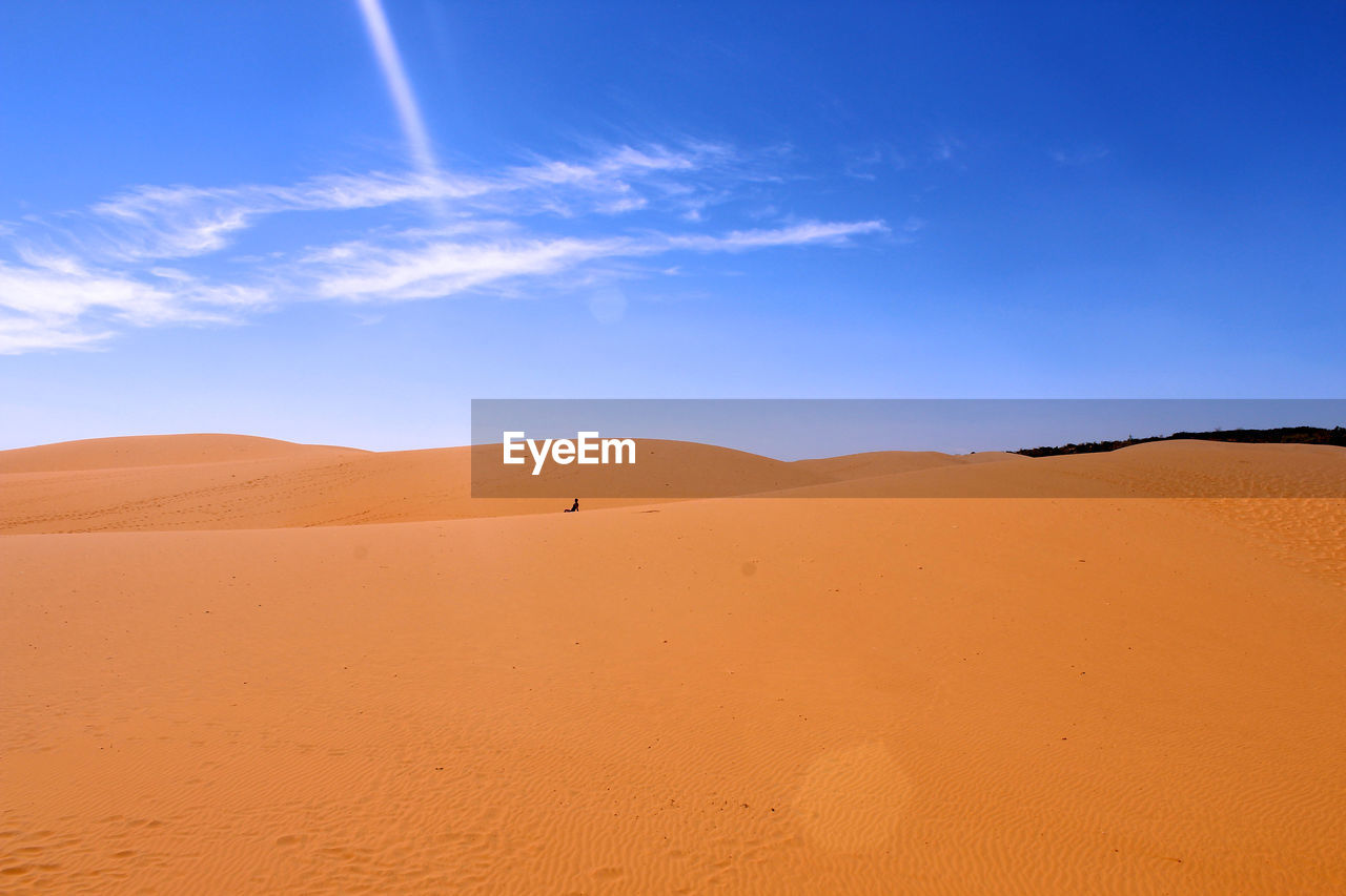 Scenic view of sand dunes against sky