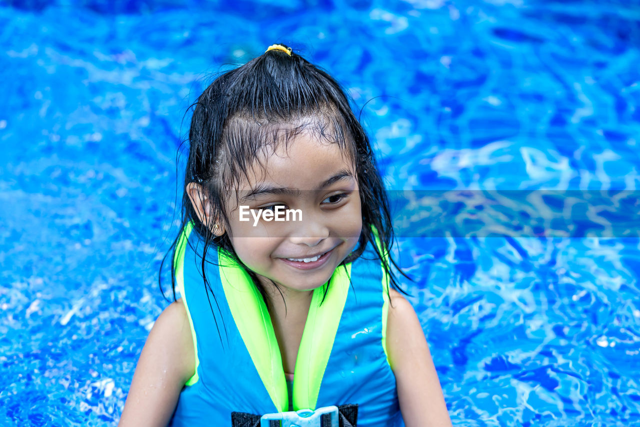 Portrait of smiling girl swimming in pool