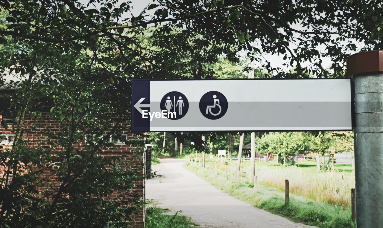 Road sign against trees