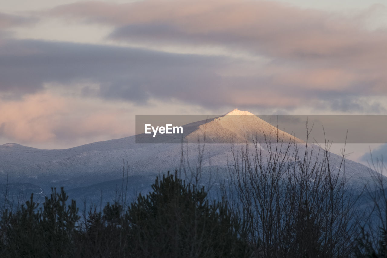 Scenic view of mountains against cloudy sky