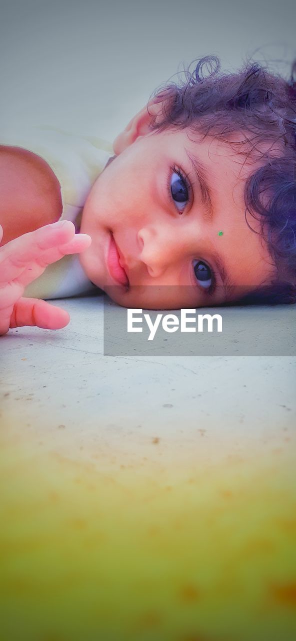 CLOSE-UP PORTRAIT OF CUTE BABY LYING DOWN ON MAN