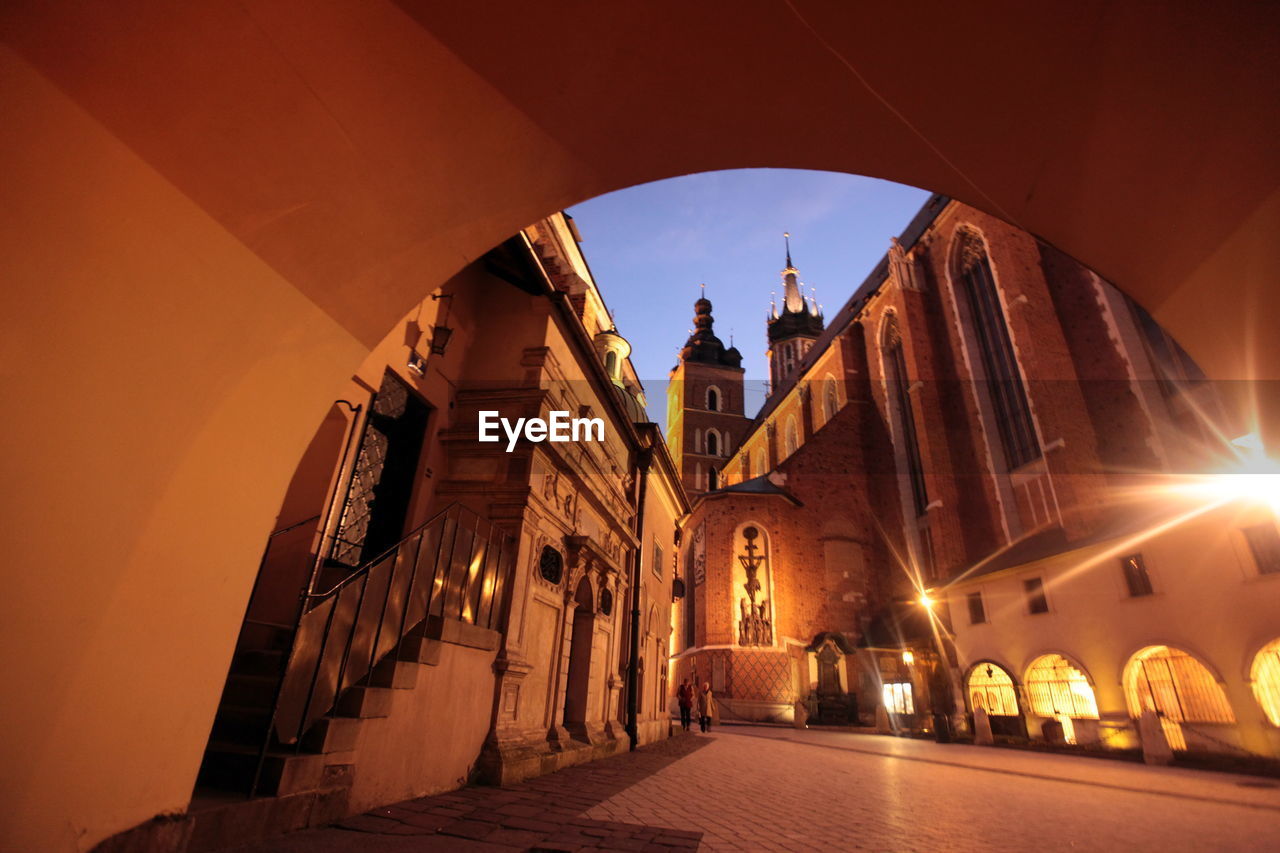 Wawel cathedral seen through illuminated tunnel at dusk