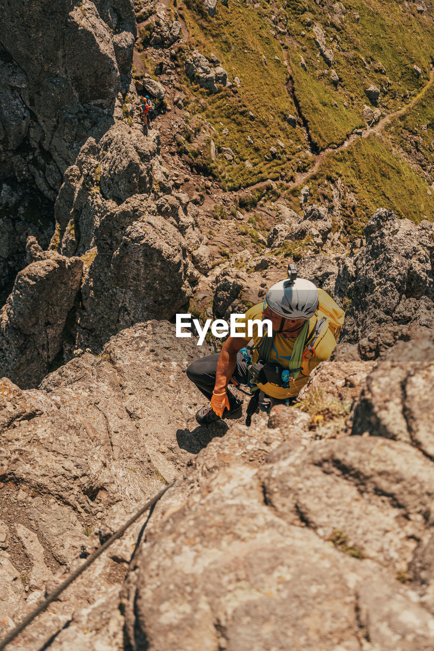 FULL LENGTH OF MAN ON ROCKS AT MOUNTAIN