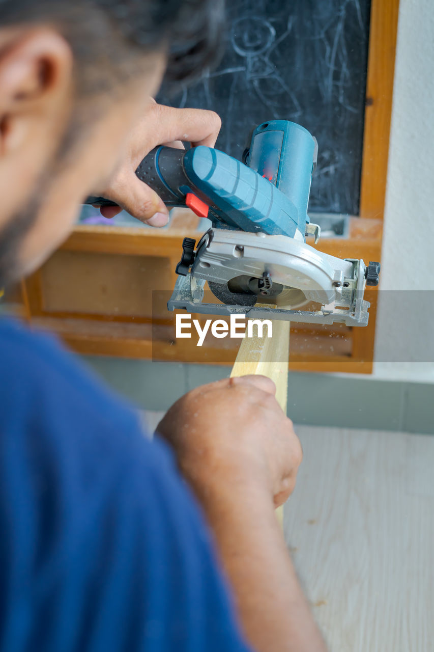 Hand held worm drive circular saw cutting boards at home. diy renovation makeover project.