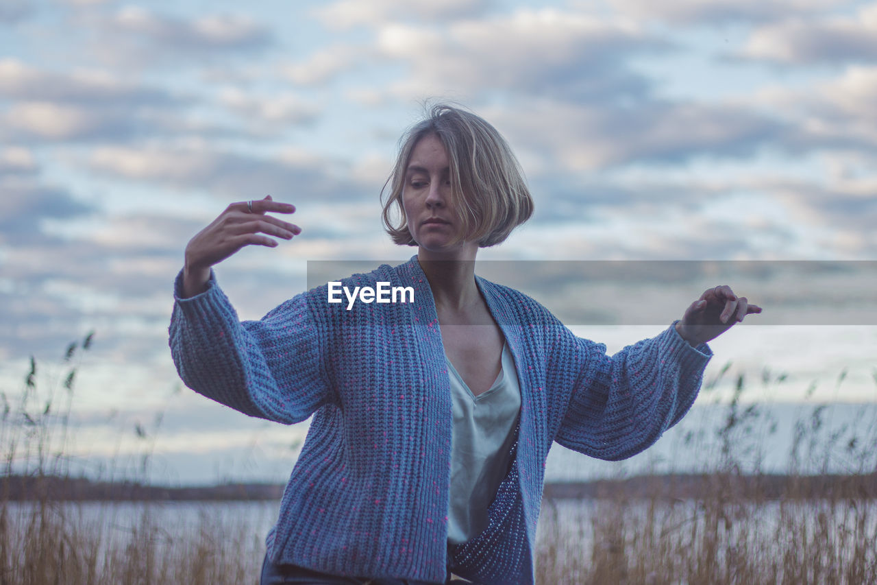 Woman dancing against sky