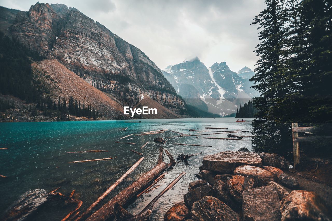 Scenic view of lake by mountains against sky