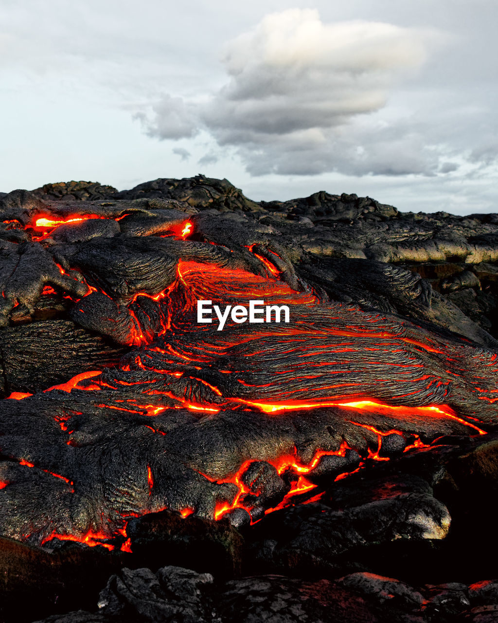 Aerial view of volcano against cloudy sky