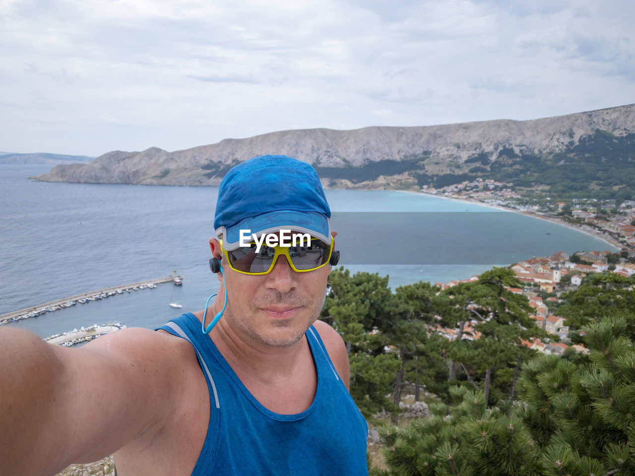 Portrait of smiling man wearing sunglasses against sea and sky