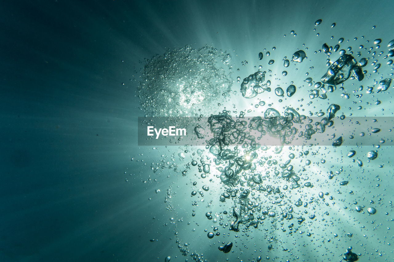Close-up of bubbles in the water against blue background