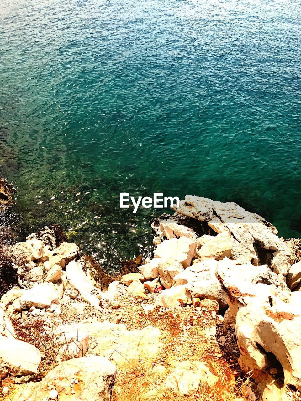 HIGH ANGLE VIEW OF ROCK IN SEA