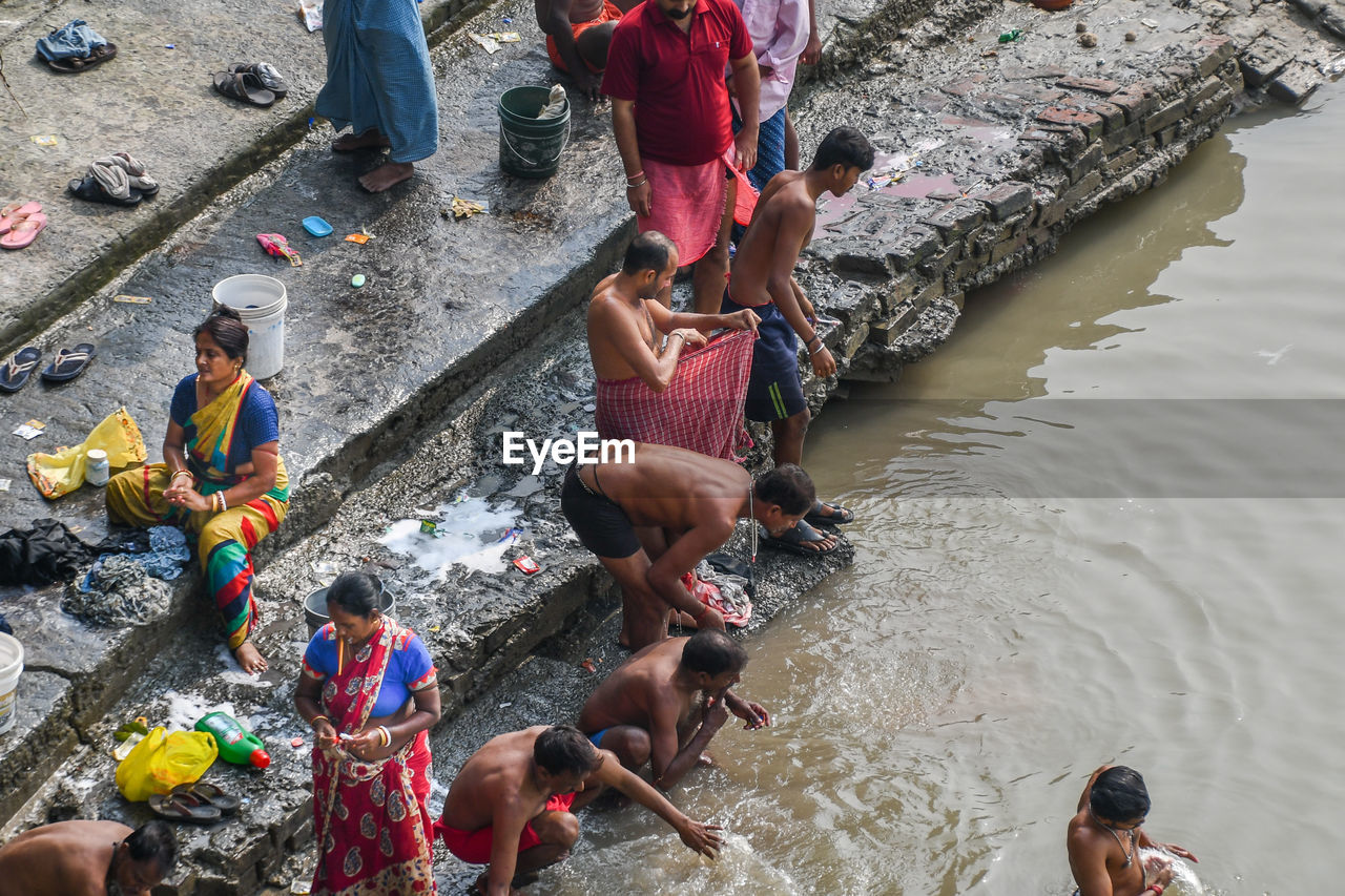 HIGH ANGLE VIEW OF PEOPLE STANDING ON RIVERBANK