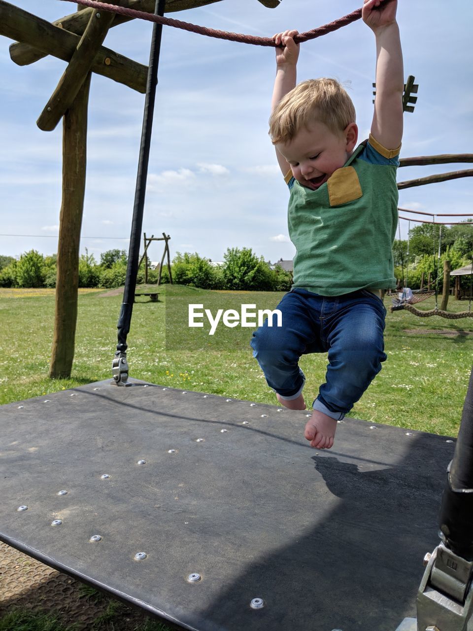 Full length of boy playing on play equipment at field