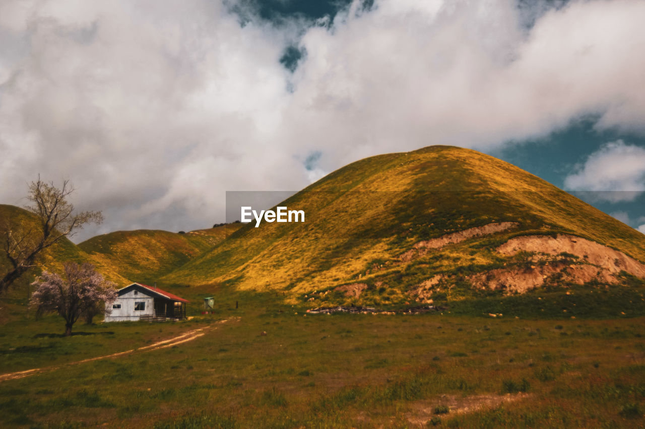 Scenic view of land and mountains against sky