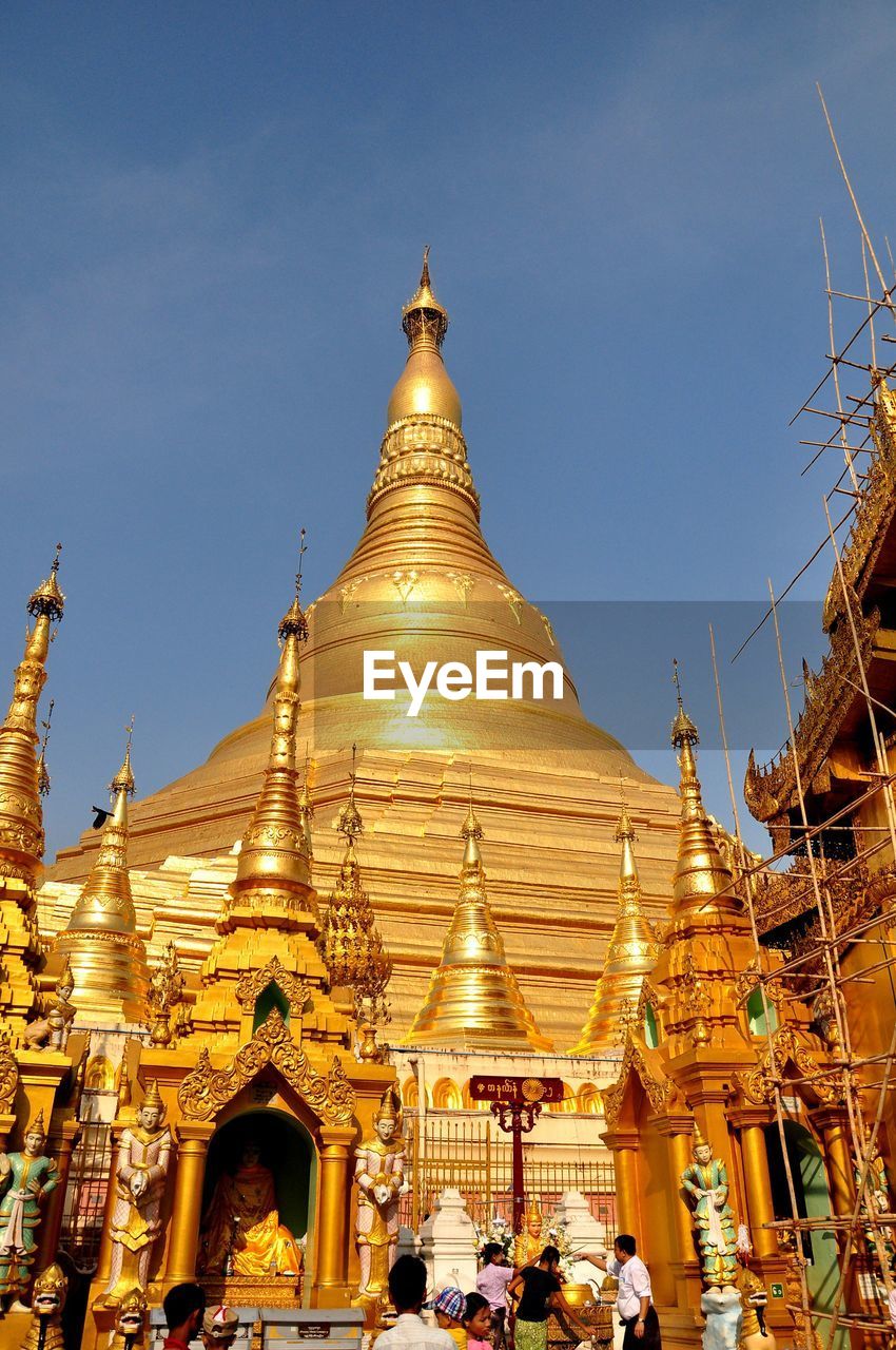 PEOPLE IN TEMPLE AGAINST SKY