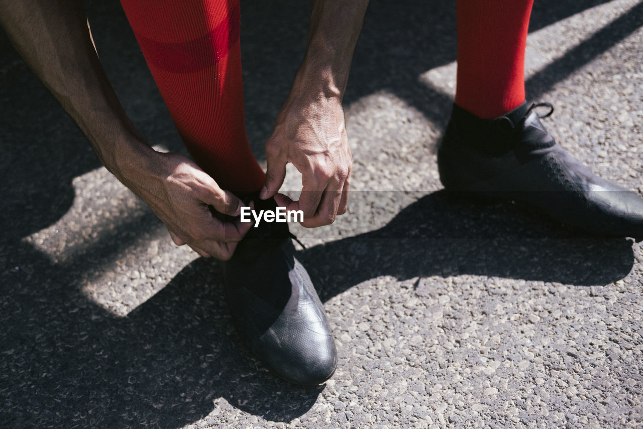 Close up of soccer player feet fixing his boots