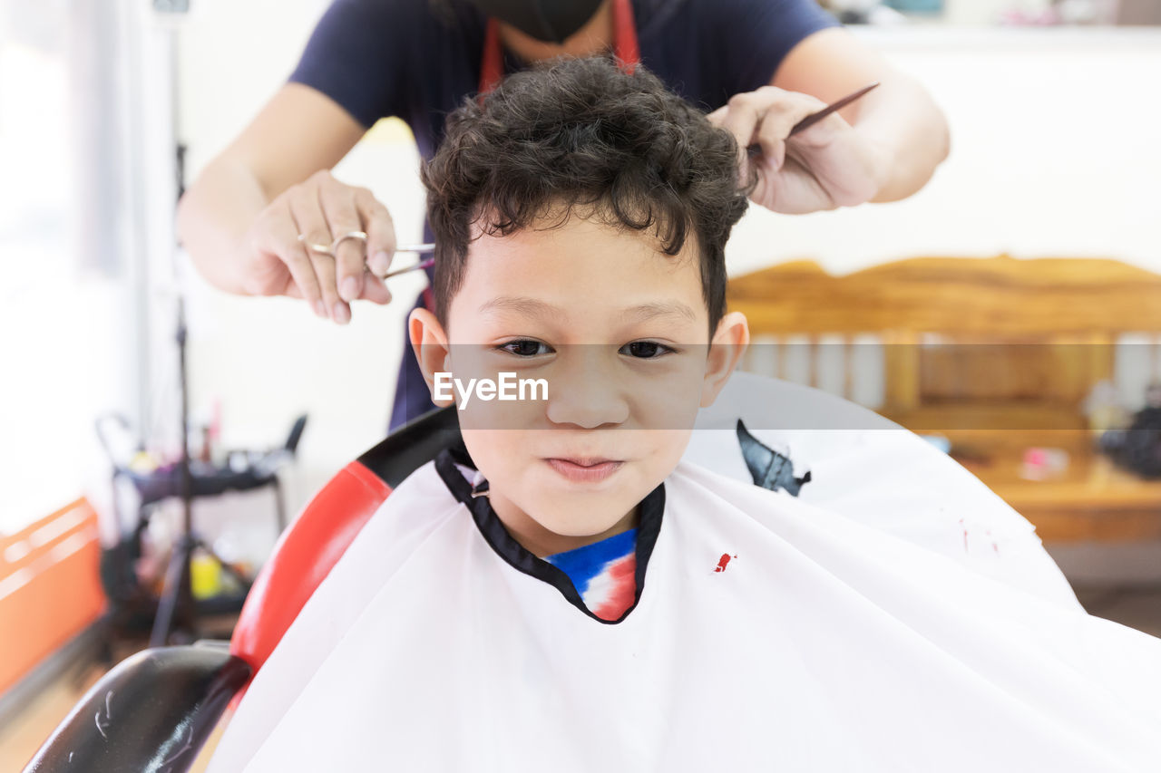 Close-up portrait of boy sitting at hair salon