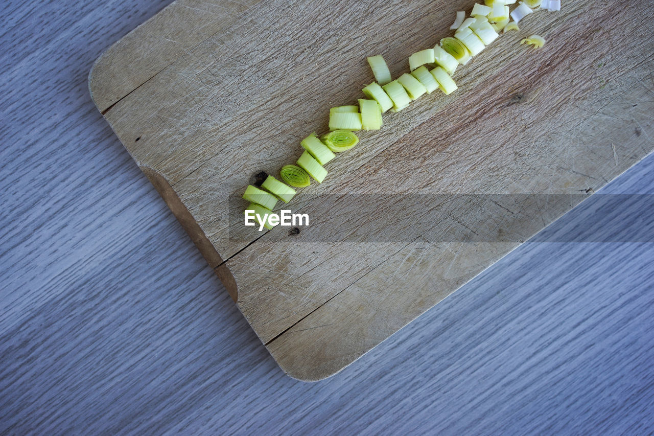 High angle view of chopped leek on cutting board at table