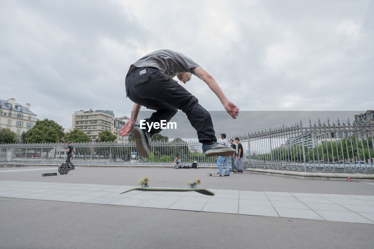 FULL LENGTH OF WOMAN JUMPING ON SKATEBOARD