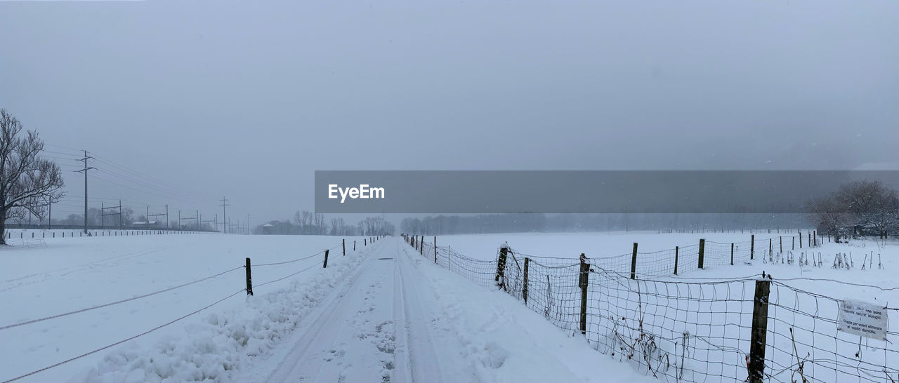 Scenic view of snow covered field against sky