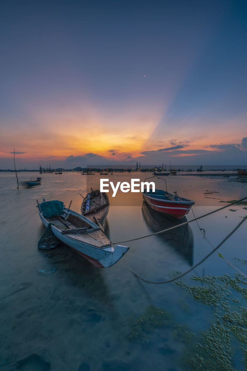 BOAT MOORED ON SEA AGAINST SKY AT SUNSET