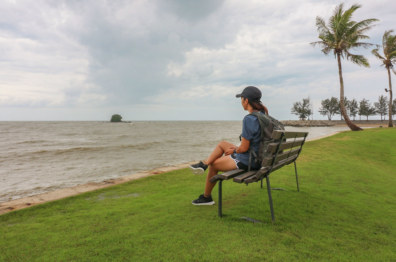 FULL LENGTH OF MAN SITTING ON CHAIR AGAINST SEA