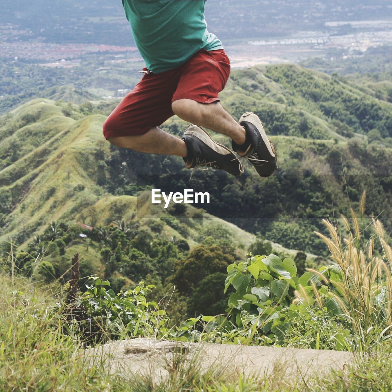 Low section of man jumping on mountain