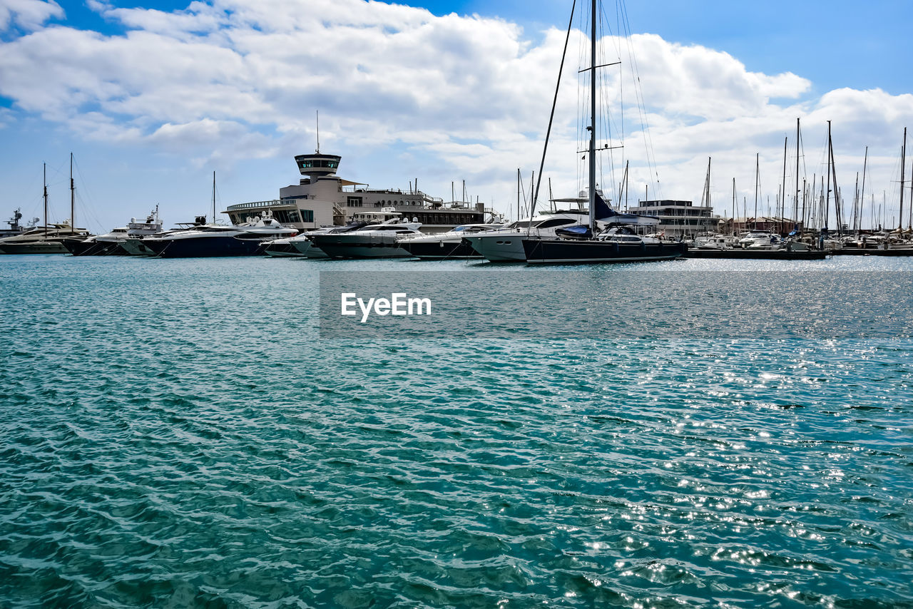 SAILBOATS MOORED IN HARBOR