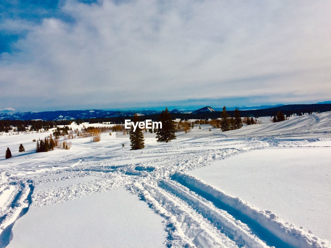 SNOW COVERED LAND AND ROAD AGAINST SKY