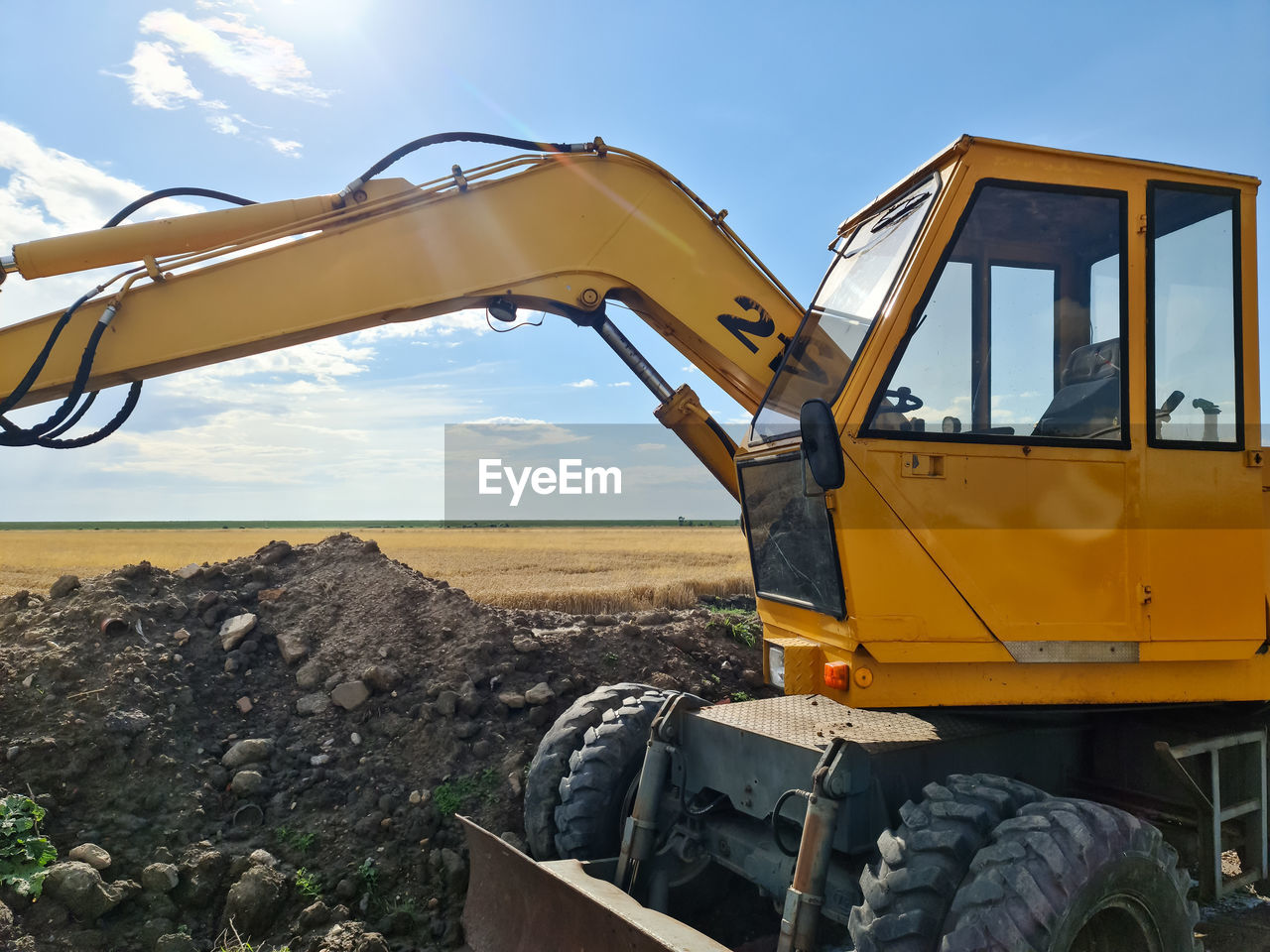 Big yellow excavator on an agriculural field